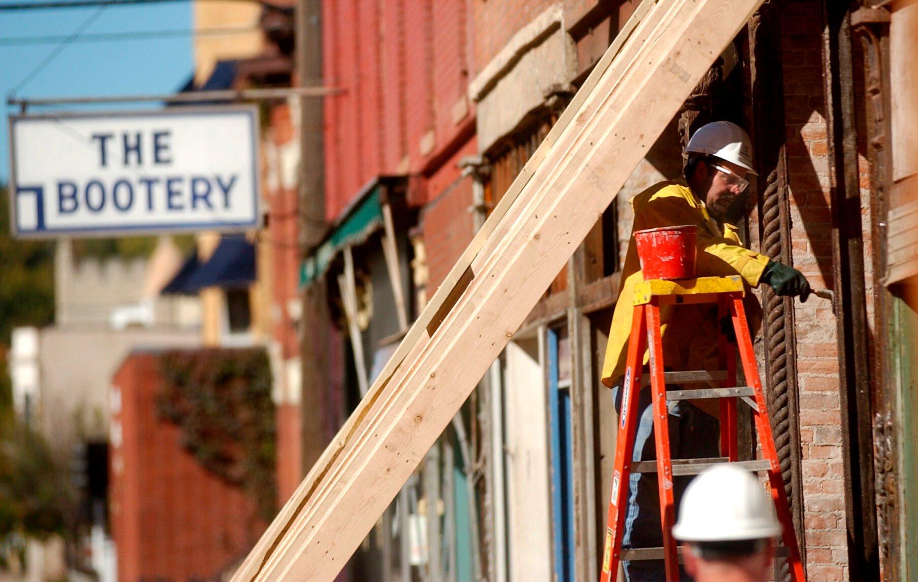 Rich Hillebrand, of Gronen Restoration, paints the exterior of a building between the 10th and 11th block of Main Street in Dubuque in September 2004.    PHOTO CREDIT: TH file