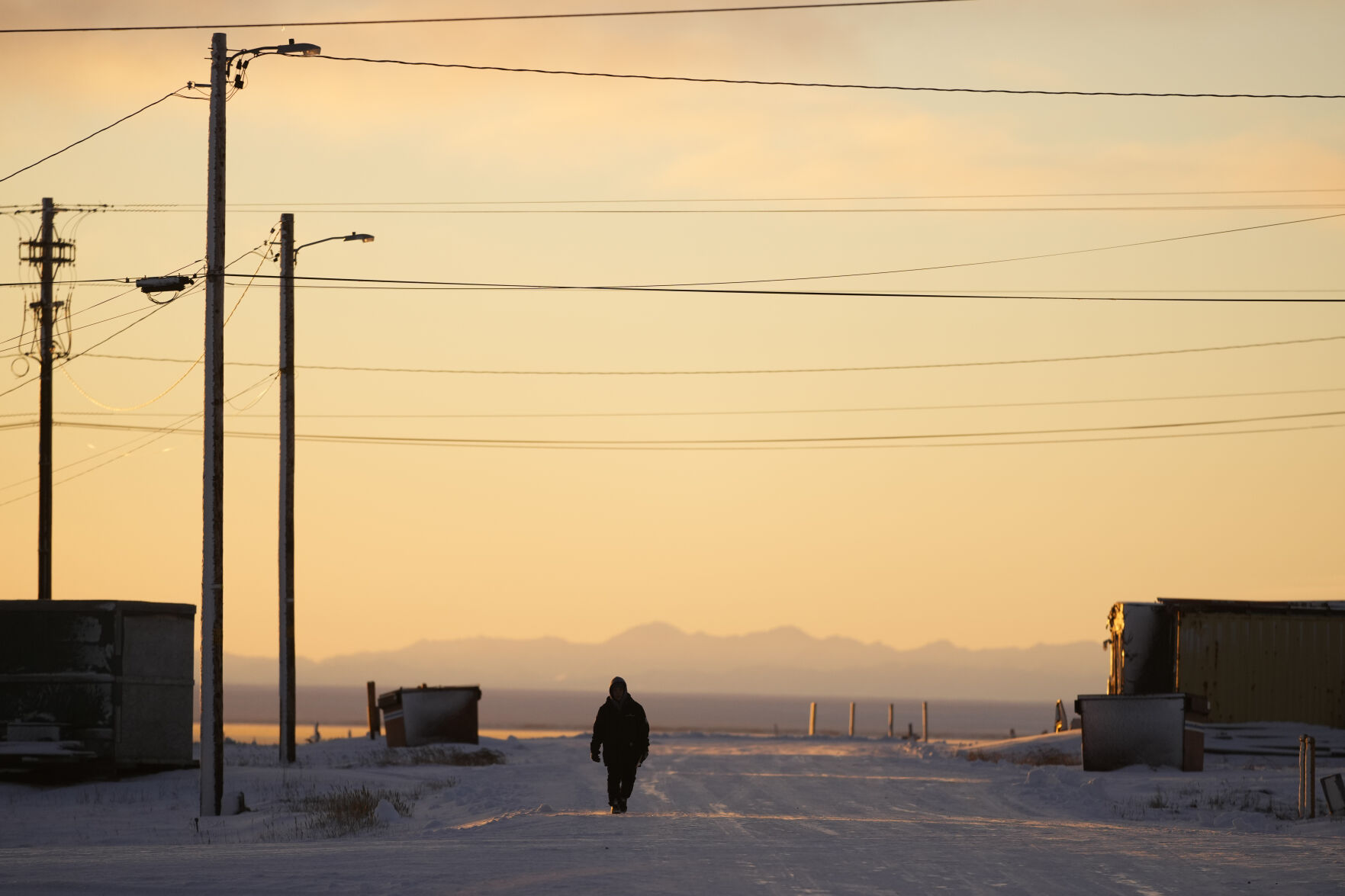 <p>A resident walks up a street as the sun rises Tuesday, Oct. 15, 2024, in Kaktovik, Alaska. (AP Photo/Lindsey Wasson)</p>   PHOTO CREDIT: Lindsey Wasson - staff, ASSOCIATED PRESS