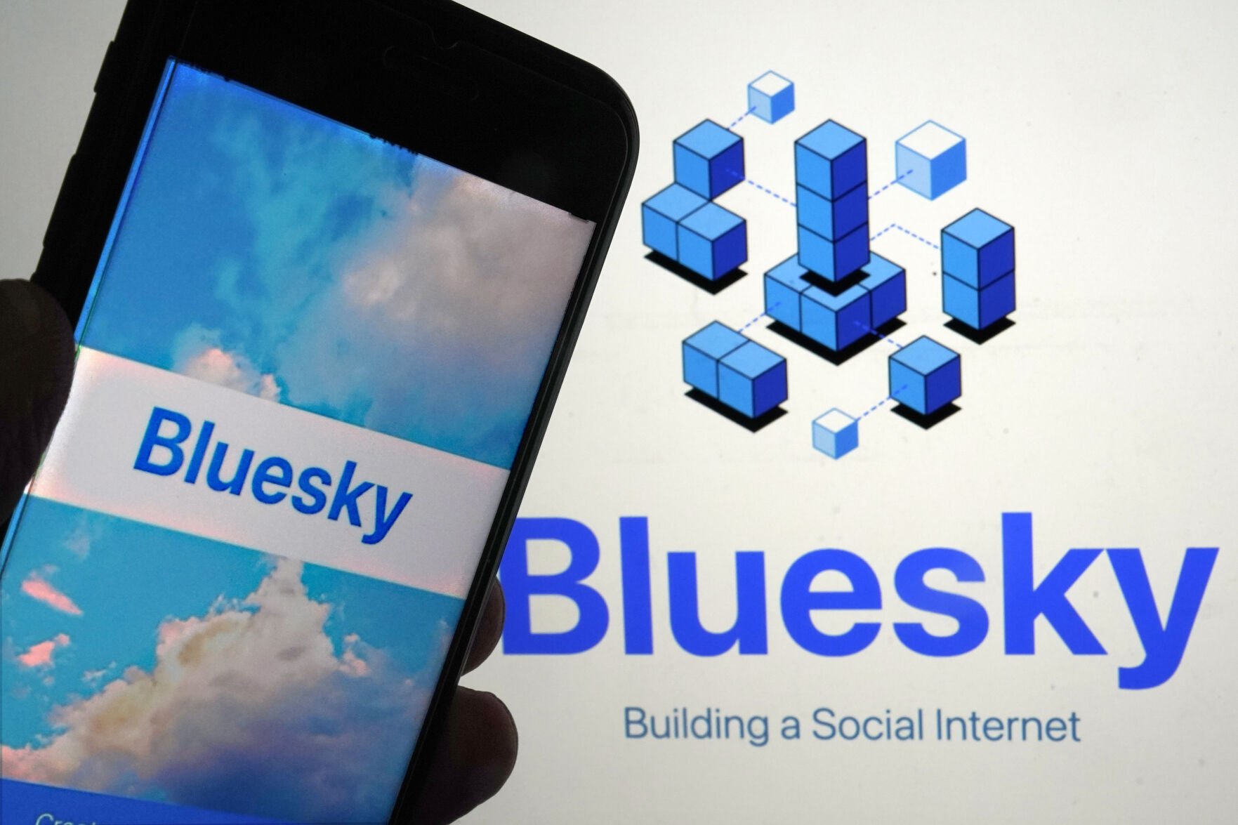 <p>FILE - The app for Bluesky is shown on a mobile phone, left, and on a laptop screen on June 2, 2023, in New York. (AP Photo/Richard Drew, File)</p>   PHOTO CREDIT: Richard Drew 