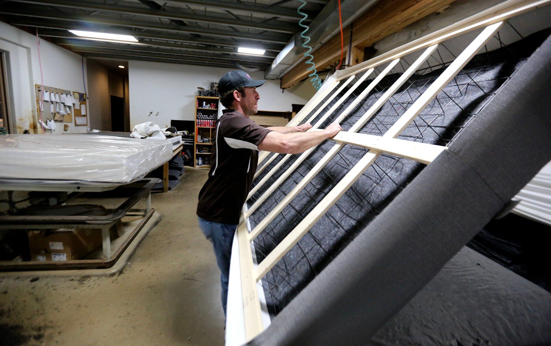 Jordan Sumners works on a building a custom mattress at Dubuque Mattress Factory.    PHOTO CREDIT: Dave Kettering
Telegraph Herald