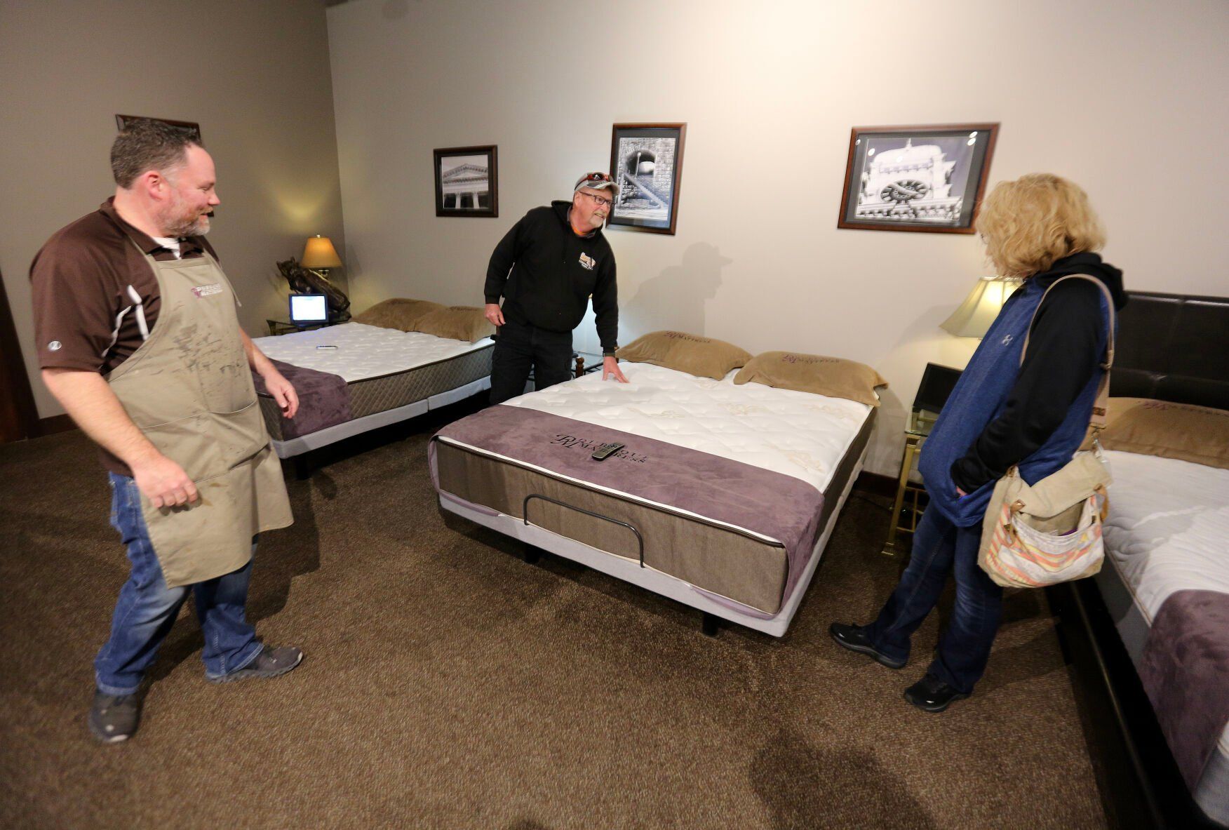 Dubuque Mattress Factory store manager Will Dunson (left) shows mattresses to customers Dan and Brenda Story, of Apple River, Wis.    PHOTO CREDIT: Dave Kettering
Telegraph Herald