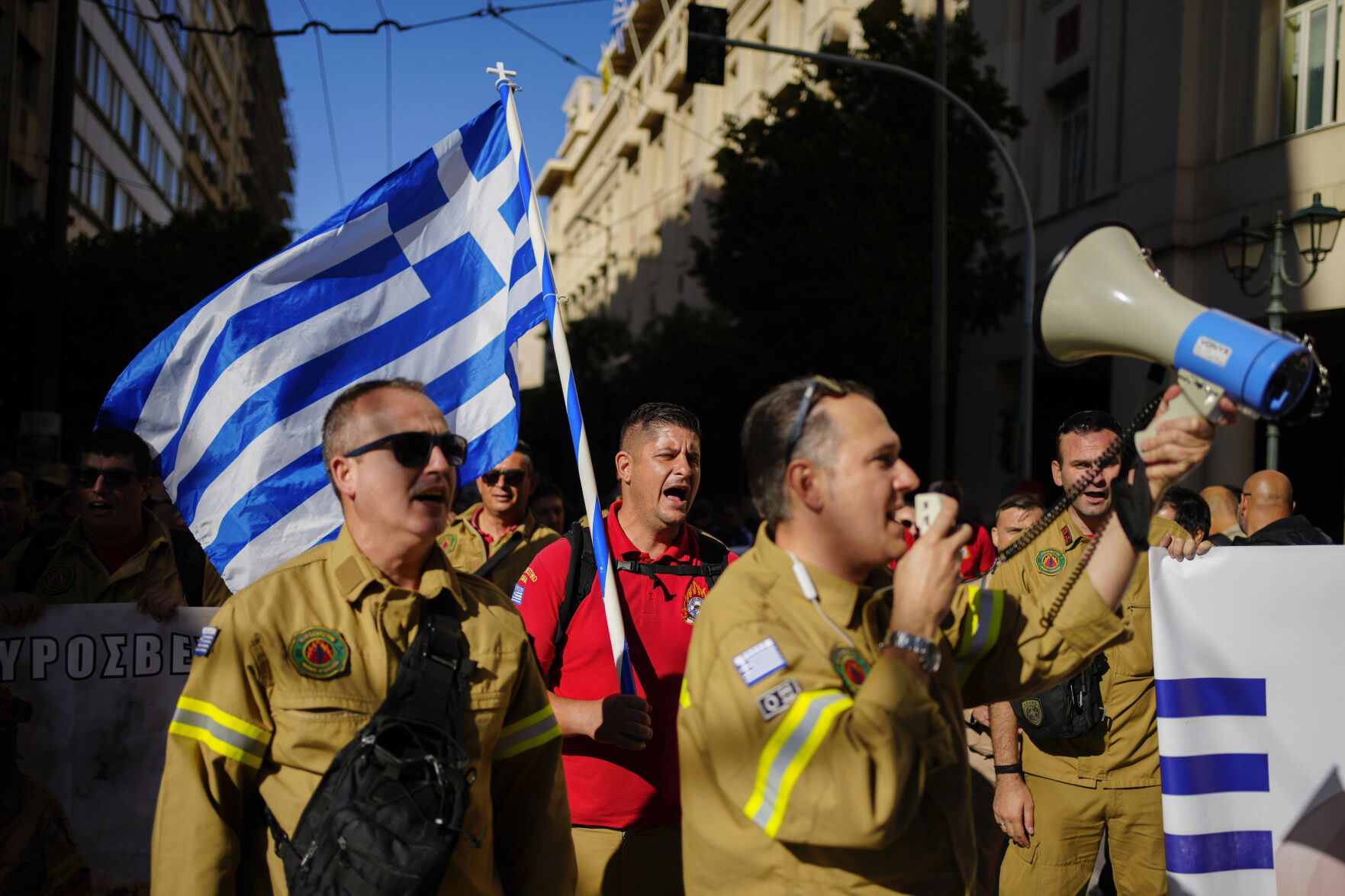 <p>Seasonal firefighters hold a Greek flag as the take part in rally, during a nationwide general strike organized by private and public sector unions demanding for better wages, in Athens, Greece, Wednesday, Nov. 20, 2024. (AP Photo/Thanassis Stavrakis)</p>   PHOTO CREDIT: Thanassis Stavrakis - staff, ASSOCIATED PRESS