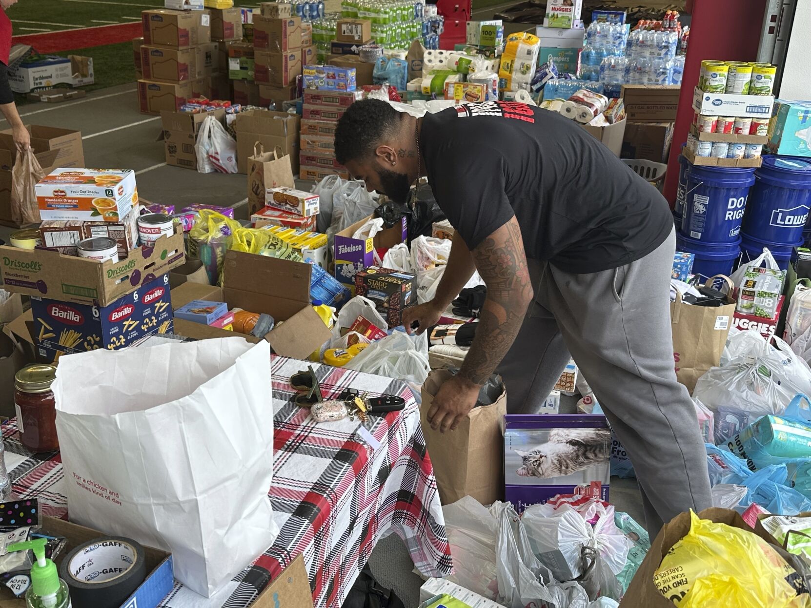 <p>FILE - N.C. State defensive end Davin Vann works among the donations collected to help Hurricane Helene victims in western North Carolina, Oct. 2, 2024 in Raleigh, N.C. (AP Photo/Aaron Beard, File)</p>   PHOTO CREDIT: Aaron Beard