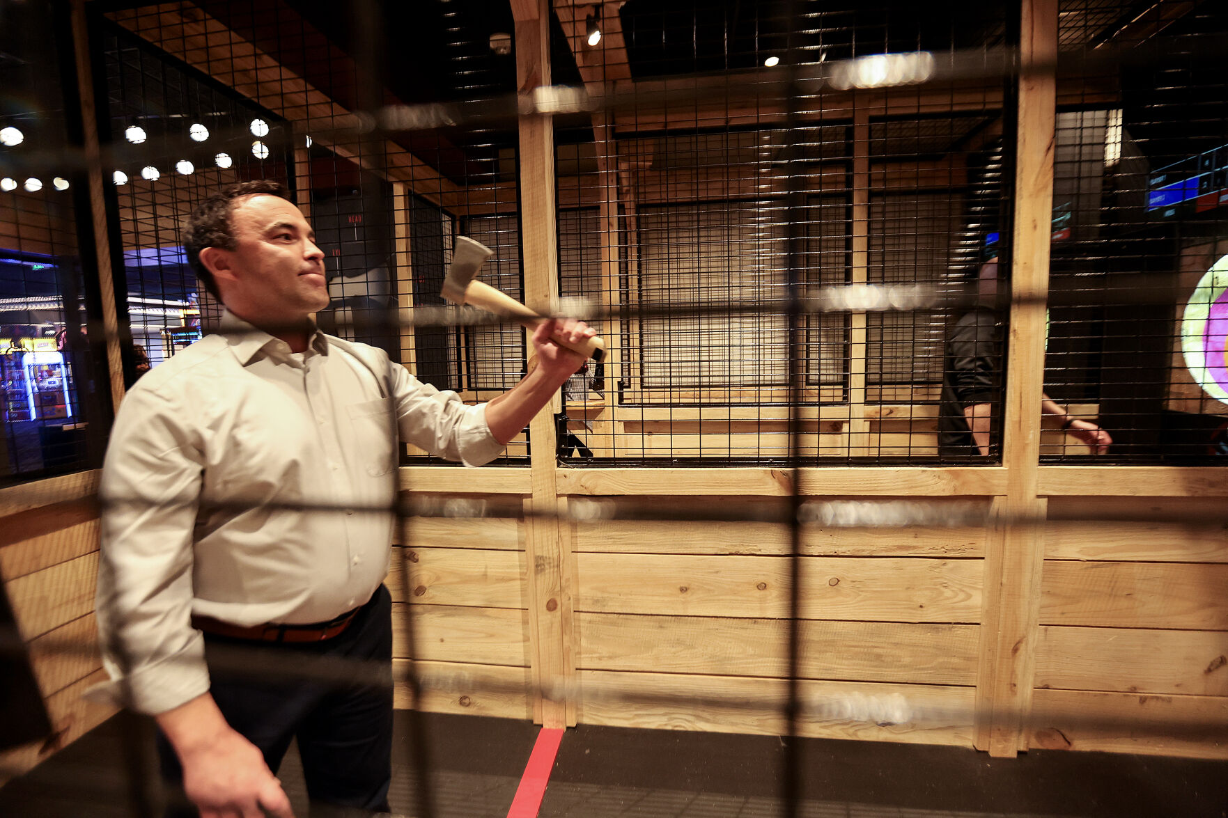 Dubuque Mayor Brad Cavanagh tries digital ax throwing.    PHOTO CREDIT: Dave Kettering