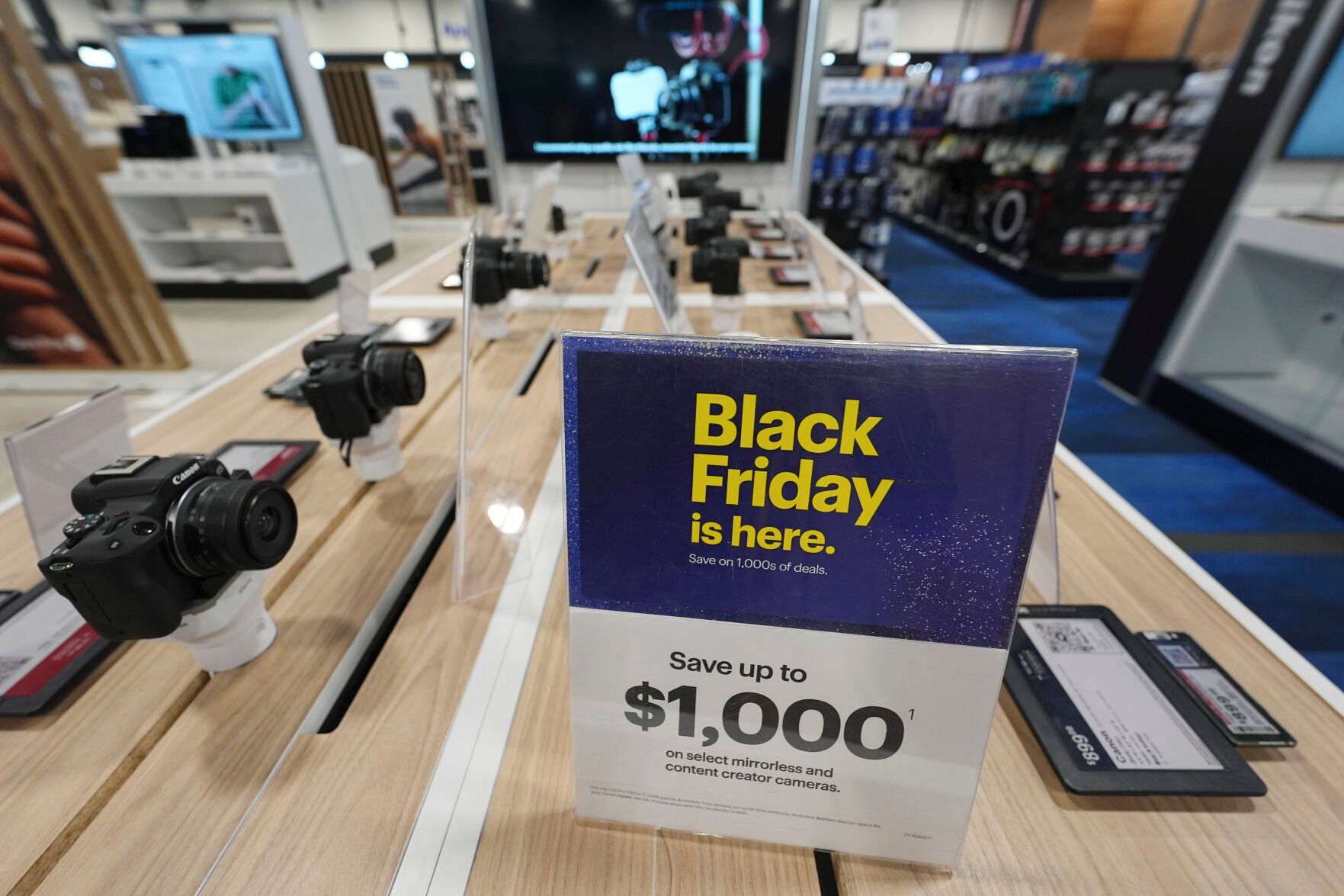 <p>A sign promoting Black Friday deals sits on table with a display of mirrorless cameras in a Best Buy store Thursday, Nov. 21, 2024, in south Denver. (AP Photo/David Zalubowski)</p>   PHOTO CREDIT: David Zalubowski - staff, ASSOCIATED PRESS