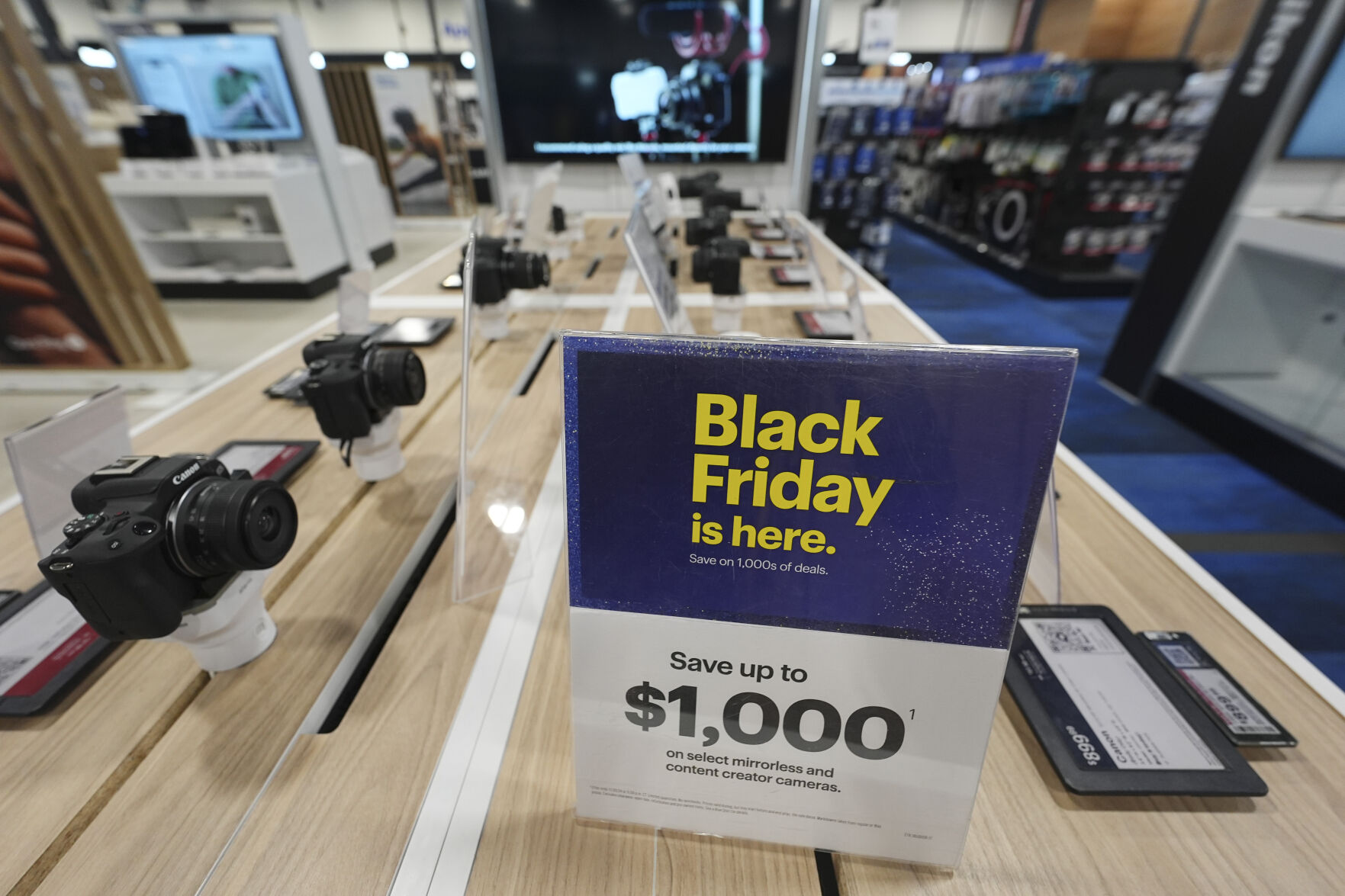 <p>A sign promoting Black Friday deals sits on table with a display of mirrorless cameras in a Best Buy store Thursday, Nov. 21, 2024, in south Denver. (AP Photo/David Zalubowski)</p>   PHOTO CREDIT: David Zalubowski - staff, ASSOCIATED PRESS