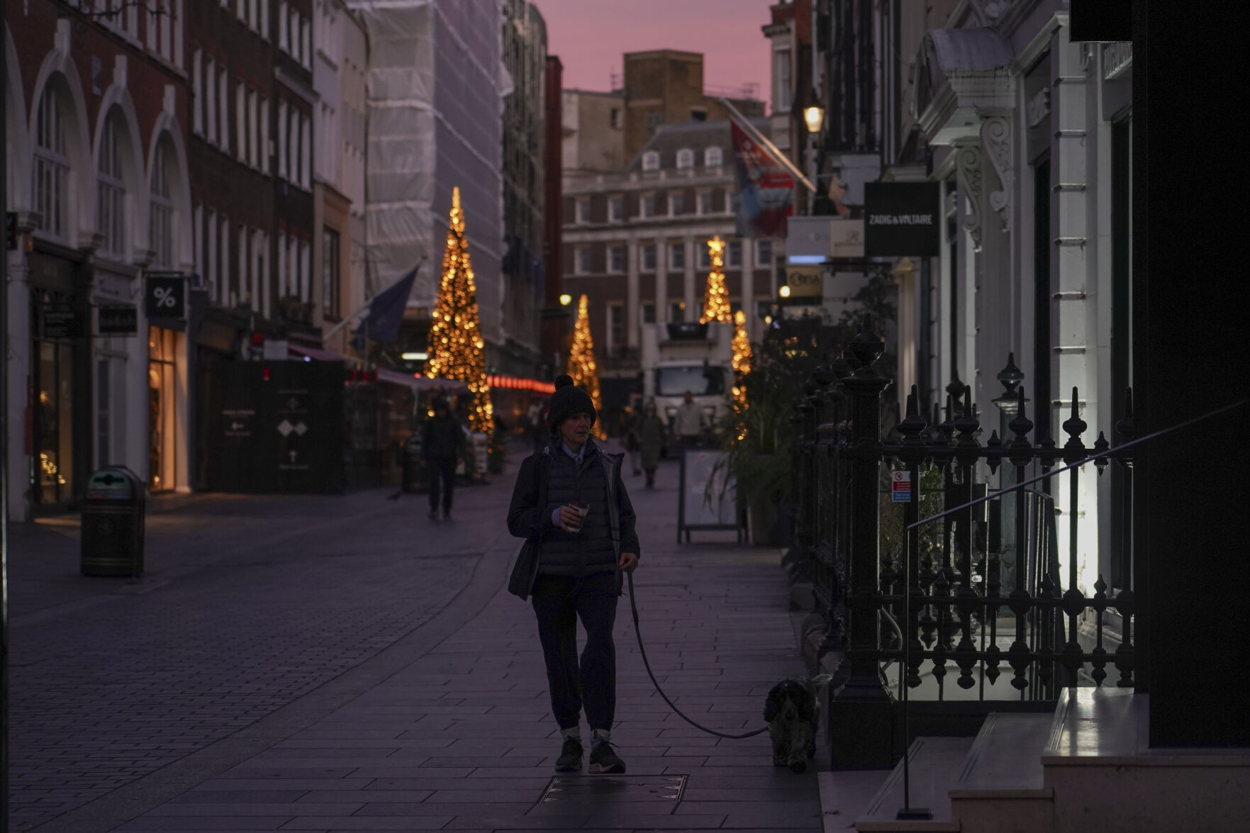 <p>A woman walks a dog in a street of Mayfair at sunrise, in London, Friday, Nov. 29, 2024.(AP Photo/Alberto Pezzali)</p>   PHOTO CREDIT: Alberto Pezzali - stringer, ASSOCIATED PRESS