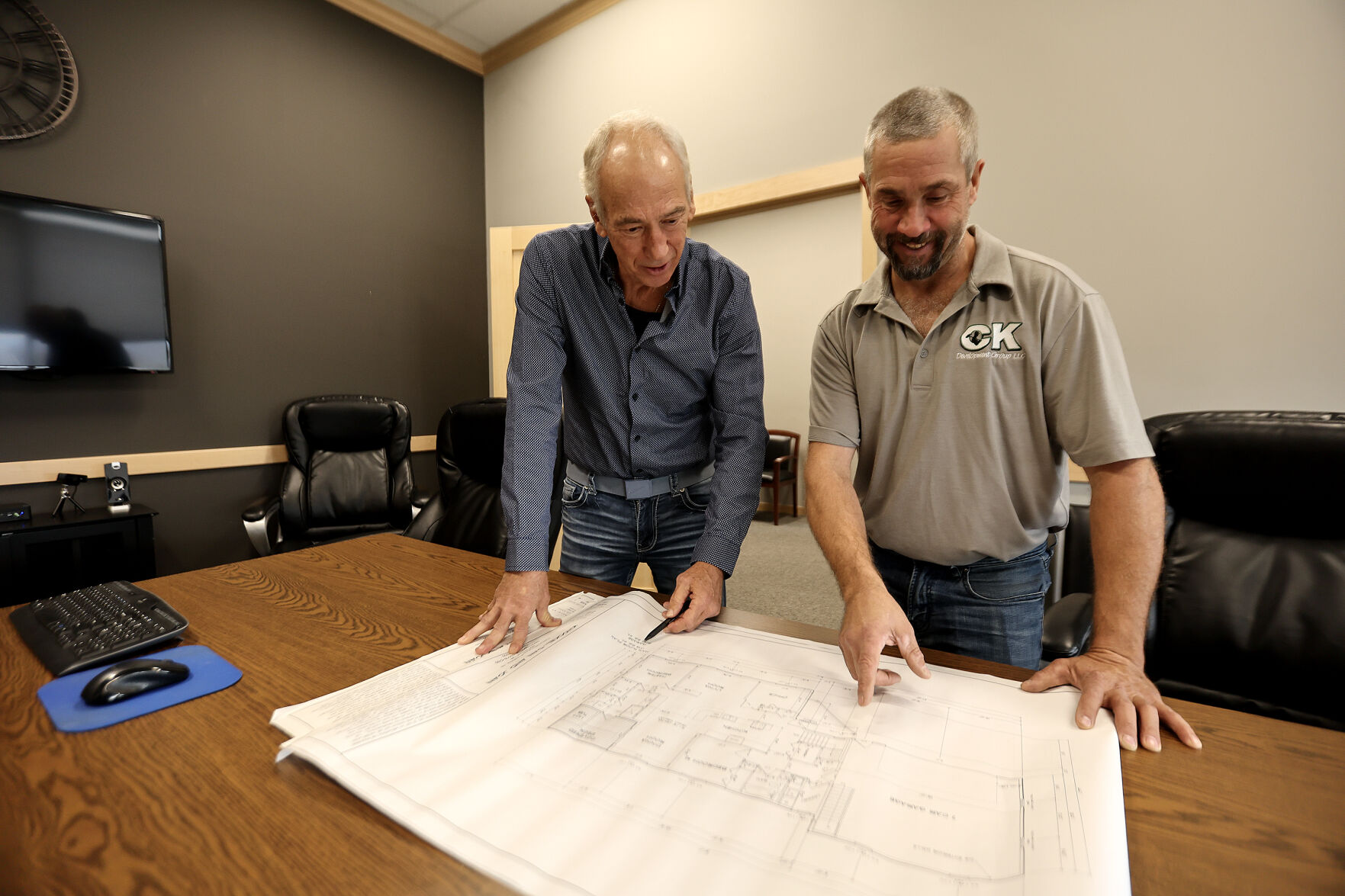 Greg Adams (left), owner and broker at RE/MAX Advantage Realty, works with client Kevin Oberbroeckling, owner of CK Construction.    PHOTO CREDIT: Dave Kettering