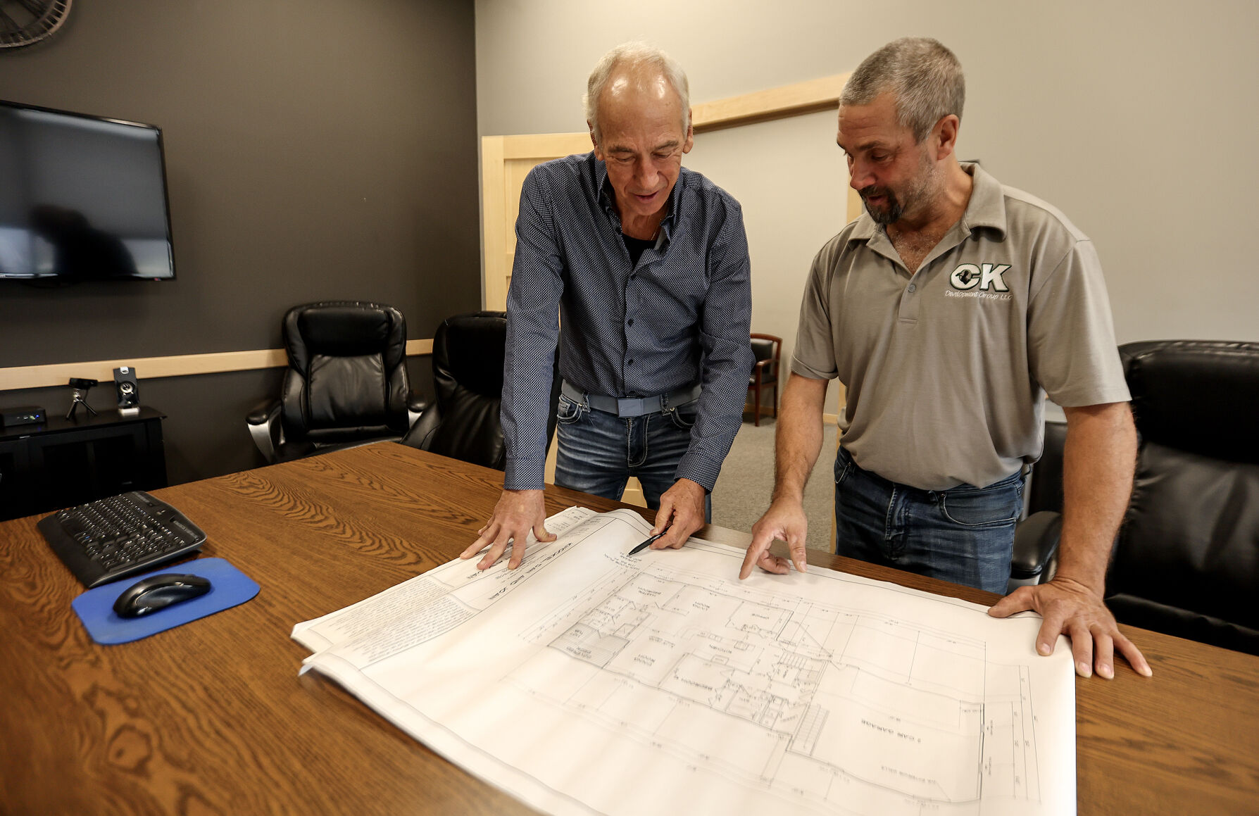 Greg Adams (left), owner and broker at ReMax Advantage Realty, works with client, Kevin Oberbroeckling owner of CK Construction.    PHOTO CREDIT: Dave Kettering