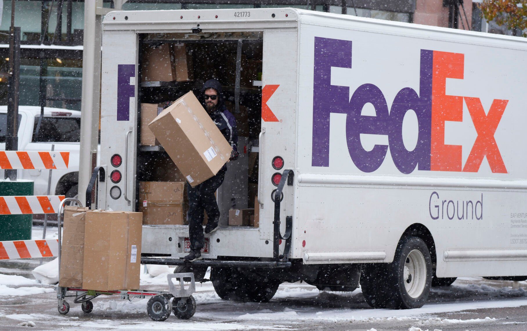 <p>FILE - A FedEx delivery person carries a package from a truck on Nov. 17, 2022, in Denver. (AP Photo/David Zalubowski, File)</p>   PHOTO CREDIT: David Zalubowski 