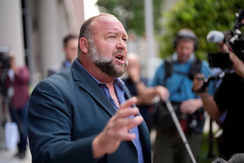 Right-wing conspiracy theorist Alex Jones speaks to the media. A bankruptcy judge scrutinizing The Onion’s bid for Jones’ Infowars platform was expected to hear a second day of testimony after an auctioneer defended the satirical news outlet’s winning offer in November.    PHOTO CREDIT: David J. Phillip