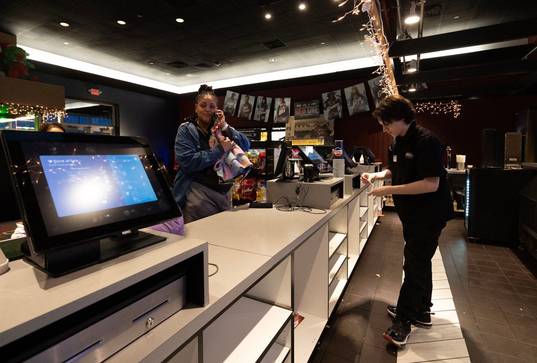 Phoenix Theatres employee Dylan Bahl gets tickets for customer Tolisa Lafayette at the Dubuque movie theater on Tuesday.    PHOTO CREDIT: Stephen Gassman