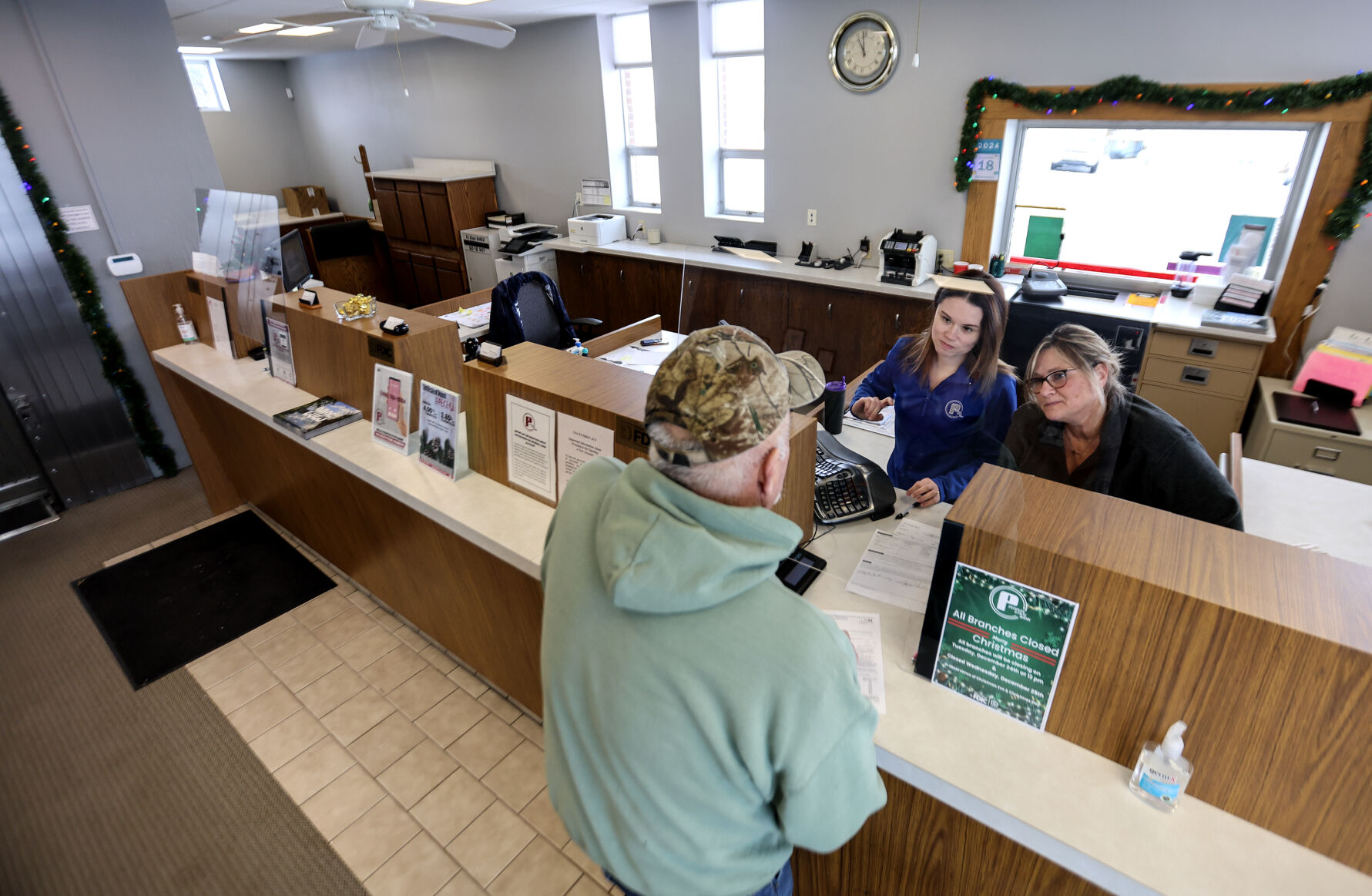 Bank teller Paige Gotto (left) and retail branch manager Amy Ginter help a customer at Peoples State Bank in Dickeyville, Wis.    PHOTO CREDIT: Dave Kettering