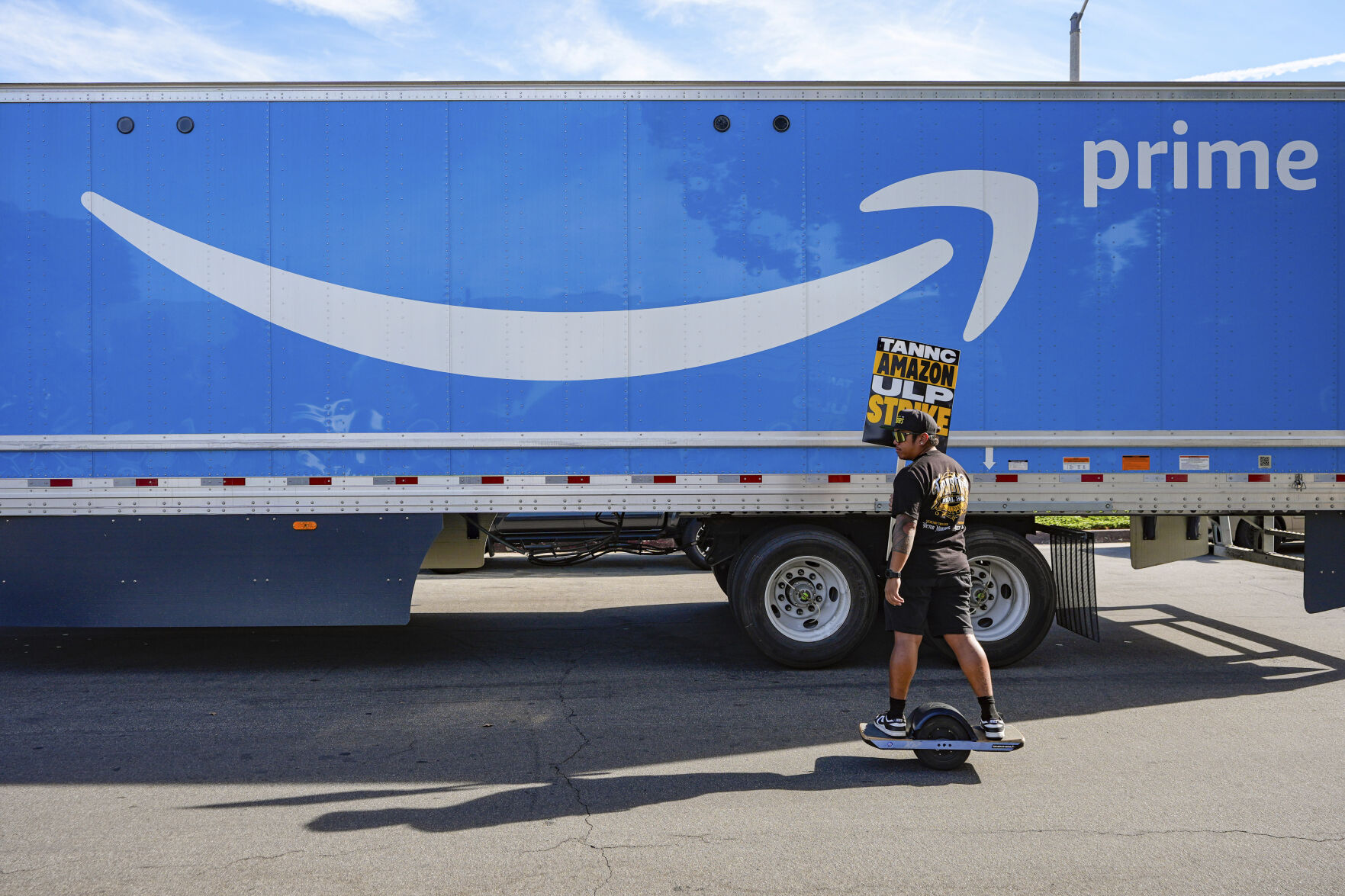 <p>UPS driver Jhon Solidum, a member of the Teamsters union, rides a one wheeler to support the Amazon workers striking outside an Amazon Fulfillment Center as Teamsters seek labor contract nationwide, Thursday, Dec. 19, 2024, in City of Industry, Calif. (AP Photo/Damian Dovarganes)</p>   PHOTO CREDIT: Damian Dovarganes - staff, ASSOCIATED PRESS