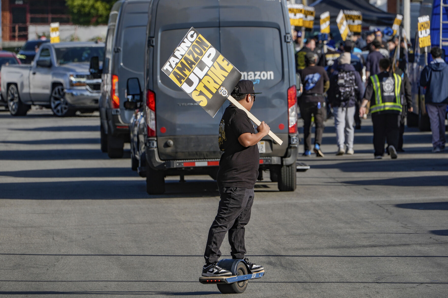 <p>UPS driver Jhon Solidum, a member of the Teamsters union, rides a one wheeler to support the Amazon workers striking outside an Amazon Fulfillment Center as Teamsters seek labor contract nationwide, Thursday, Dec. 19, 2024, in City of Industry, Calif. (AP Photo/Damian Dovarganes)</p>   PHOTO CREDIT: Damian Dovarganes - staff, ASSOCIATED PRESS