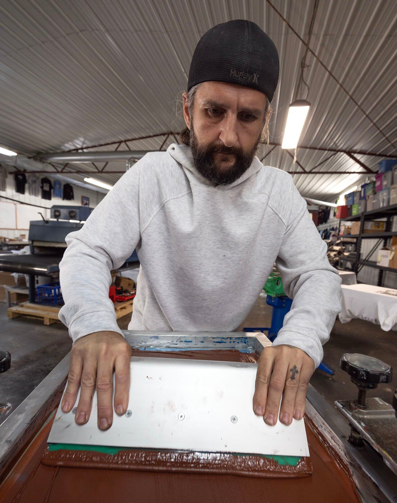 Matt Folstad screen prints a shirt at Dubuque Clothing Co.    PHOTO CREDIT: Stephen Gassman